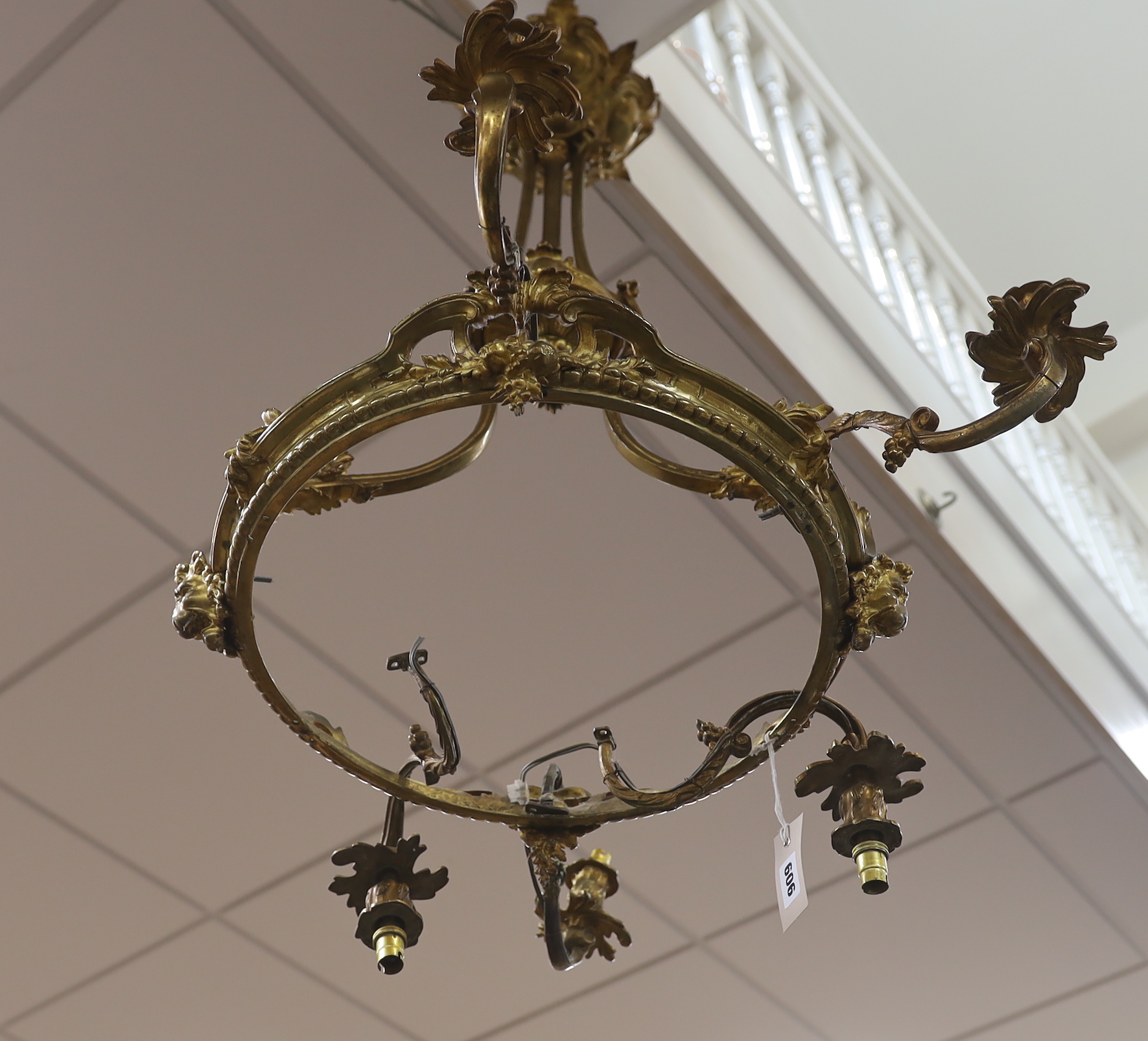 A gilt metal five branch chandelier, decorated with masks, 78cm high